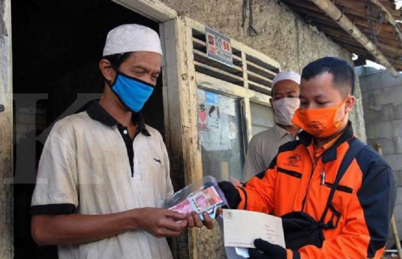 ILUSTRASI. Petugas Pos Indonesia menyerahkan bantuan sosial tunai kepada Keluarga Penerima Manfaat (KPM) di Kampung Pabuaran Cibadak RT 02/03 Kelurahan Cibadak, Tanah Sareal, Kota Bogor, Jawa Barat, Rabu (22/4) (kontan.co.id)