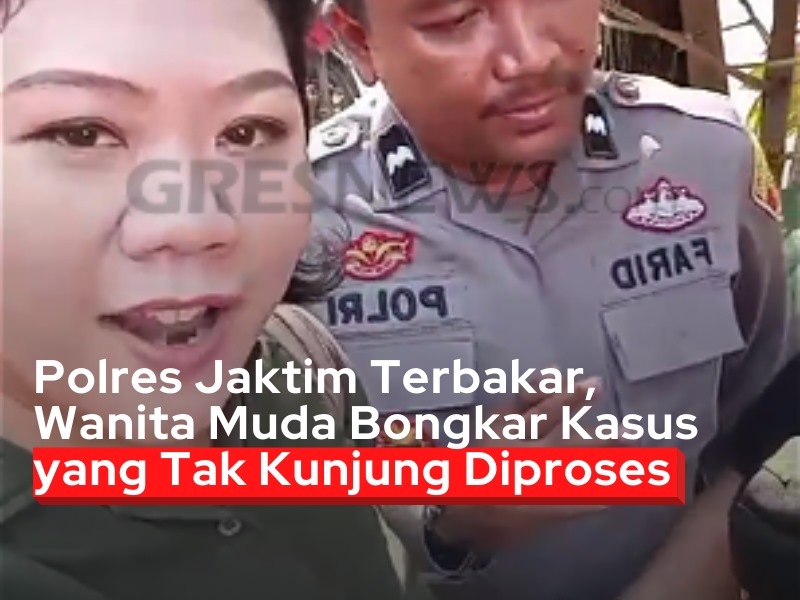 Seorang wanita muda berdiri di depan Polres Jakarta Timur yang terbakar akibat aksi massa pada Sabtu pagi (30/08/2025).