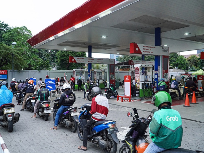 Ilustrasi warga beli bensin di pom bensin.